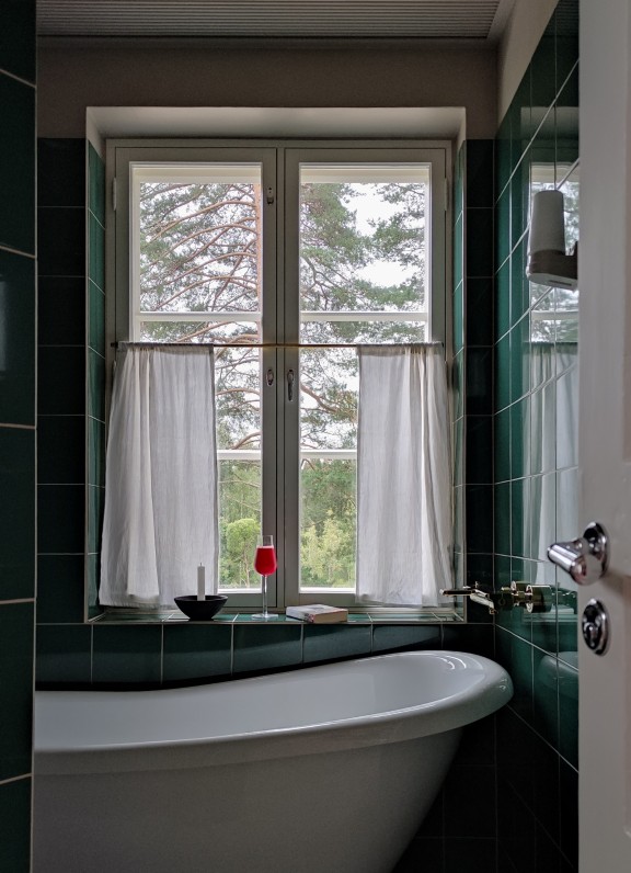 bathroom with green tiles and beige detail in seams