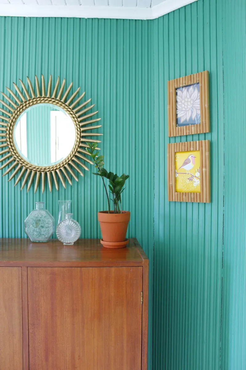 bright green wall in hallway, decorated with wooden furniture